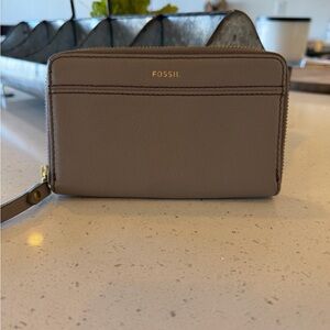 Fossil Jori Zip Clutch in a taupe or gray leather material.